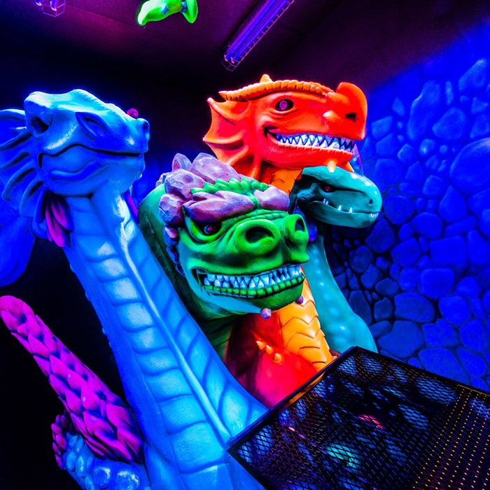 Dragon's Tale blacklight mini-golf birthday party at West Edmonton Mall, featuring group admission packages, party room rentals, and add-ons like the Crystal Labyrinth Mirror Maze for an unforgettable birthday celebration.